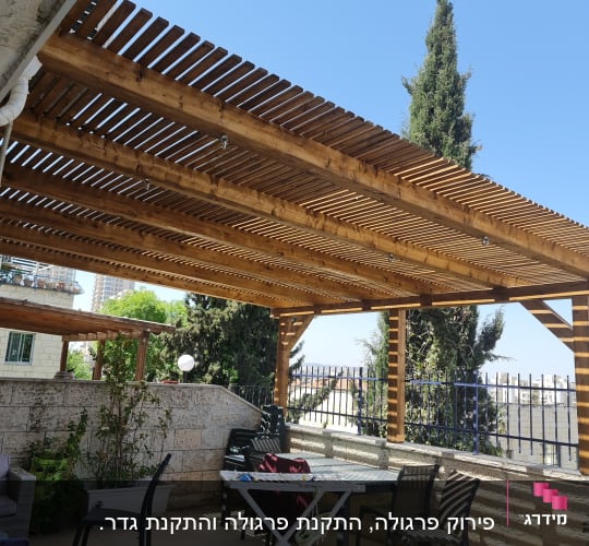 פרגולה מעץ עם כיסאות ושולחן בגינה